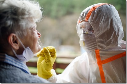 Taking corona virus test sample from nose of senior woman, quarantine concept.