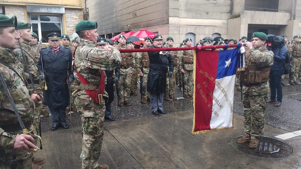Militares realizando el juramento a la bandera bajo la lluvia en la Plaza de la República de Valdivia.