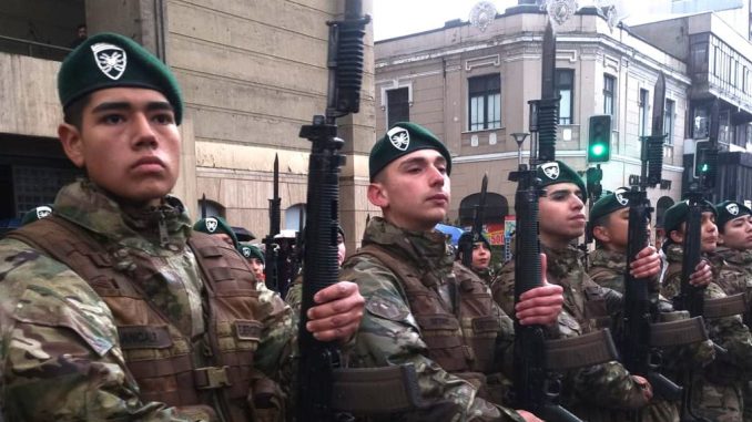 Militares realizando el juramento a la bandera bajo la lluvia en la Plaza de la República de Valdivia.