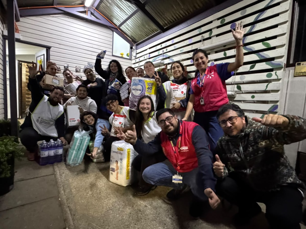 Voluntarios y personal municipal descargando cajas de ayuda humanitaria de un camión de Walmart Chile para familias afectadas por temporales en Valdivia.