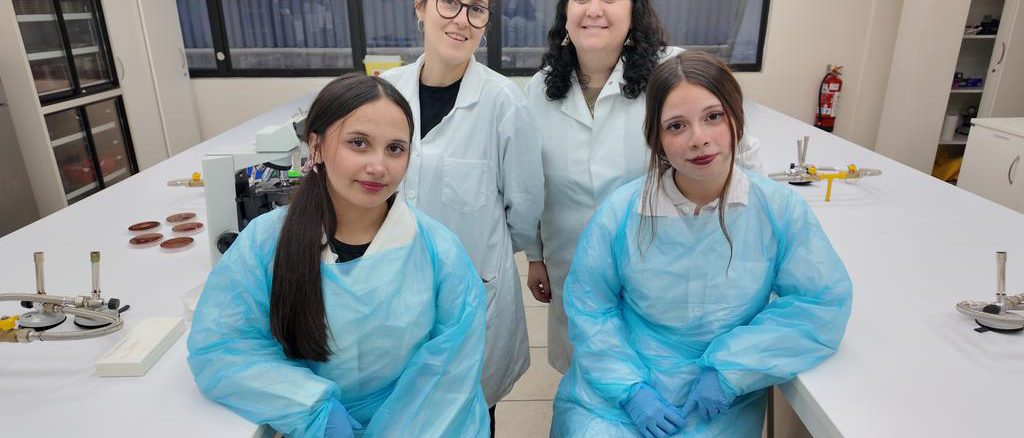 Estudiantes realizando análisis microbiológico en laboratorio junto a docente de la Universidad Santo Tomás