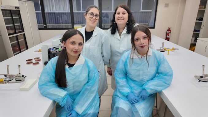 Estudiantes realizando análisis microbiológico en laboratorio junto a docente de la Universidad Santo Tomás