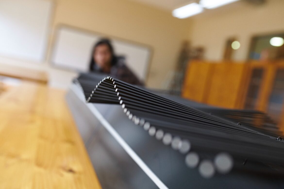 Estudiante de Magíster Esteban Alarcón explicando su investigación sobre metamateriales acústicos y simetría