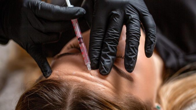 Médico especialista aplicando tratamiento con toxina botulínica en entorno clínico