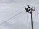 Operarios de Saesa realizando labores de mantenimiento en la red eléctrica durante un día nublado