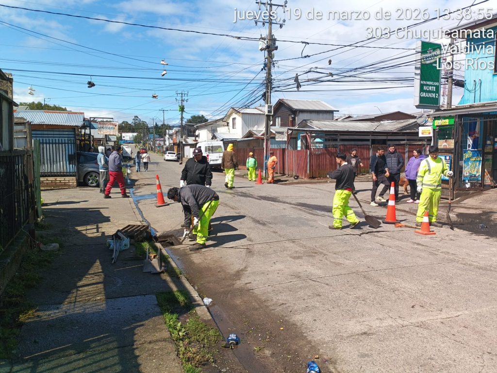 Equipos municipales de Valdivia realizando labores de limpieza y drenaje durante un temporal de lluvias.