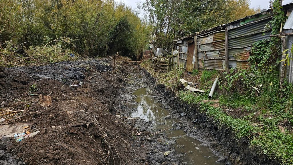 Equipos municipales de Valdivia realizando labores de limpieza y drenaje durante un temporal de lluvias.