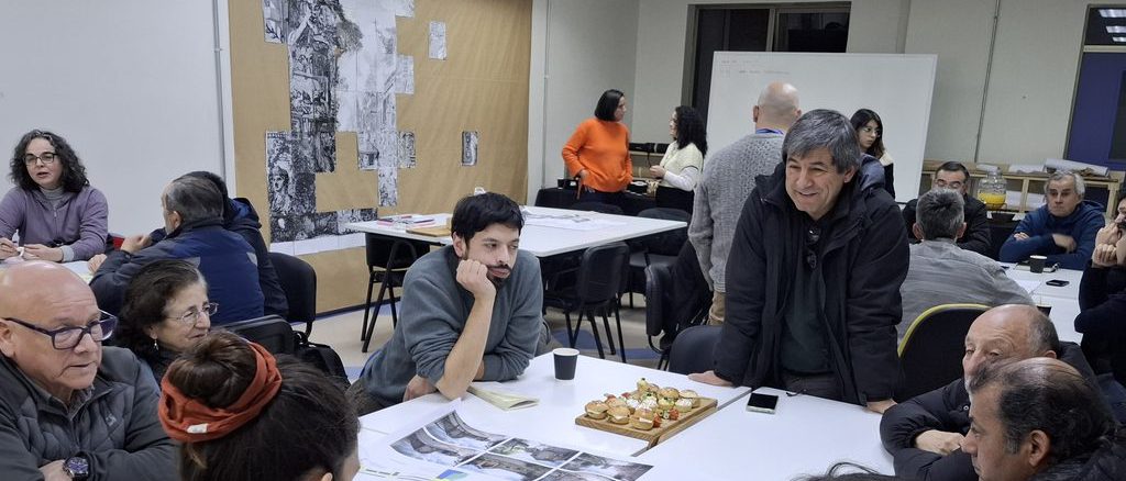 Vecinos y autoridades municipales revisando los planos del diseño final para el proyecto Pasaje Orella en Valdivia