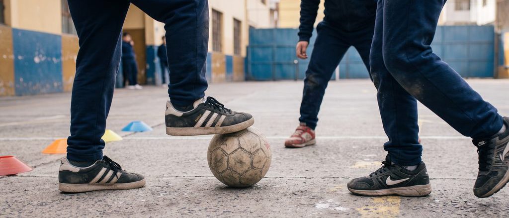 Estudiantes participando en actividades físicas y juegos recreativos en un patio escolar chileno