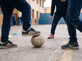Estudiantes participando en actividades físicas y juegos recreativos en un patio escolar chileno