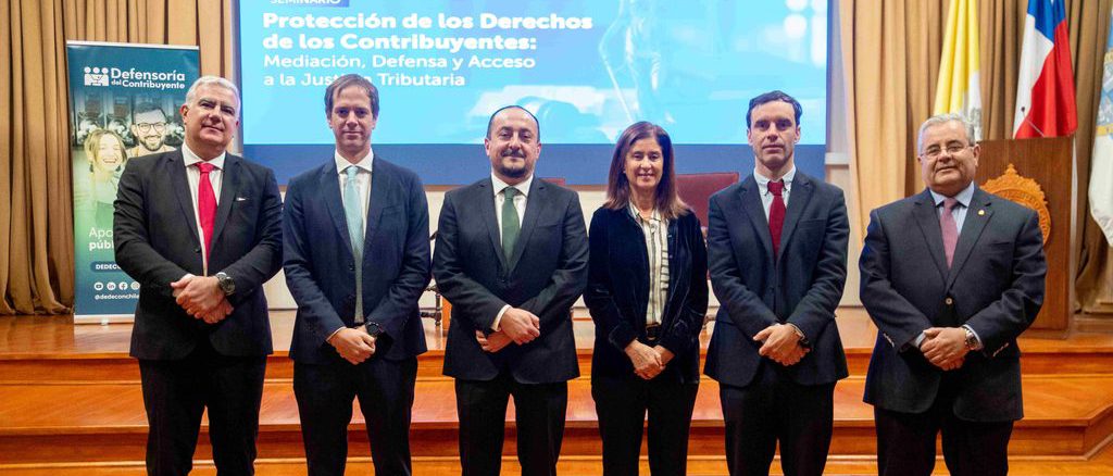 Especialistas y académicos analizando los derechos de los contribuyentes en un seminario jurídico