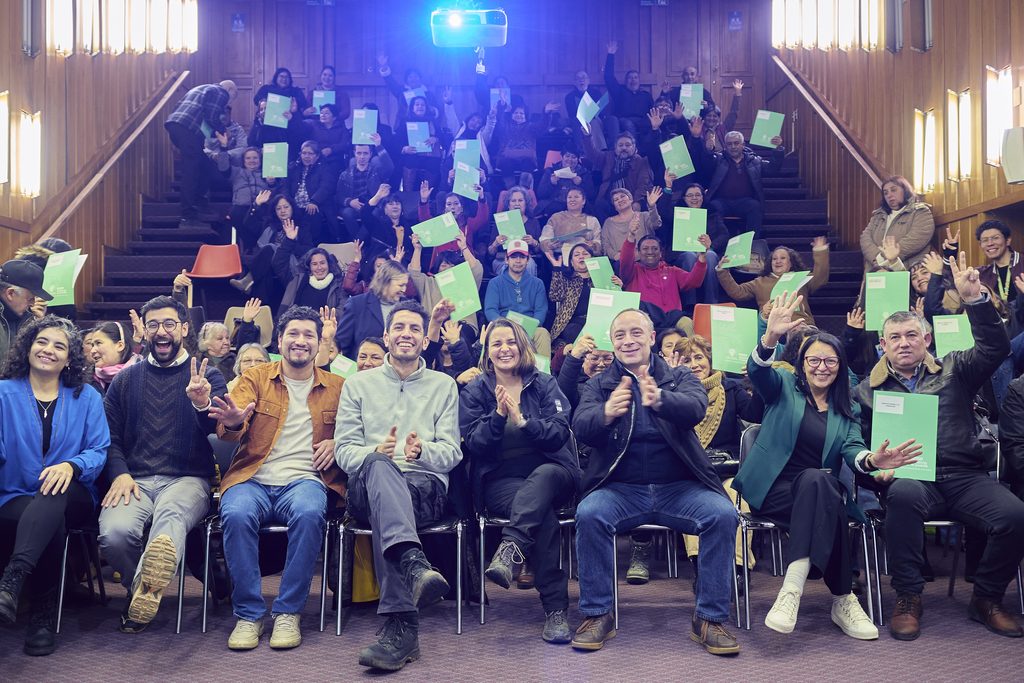 Vecinos en una sede social de Valdivia celebrando la entrega de fondos municipales para infraestructura.