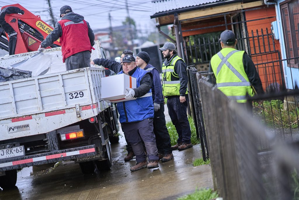 Personal municipal de Valdivia entregando kits de ayuda a familias damnificadas por las intensas lluvias