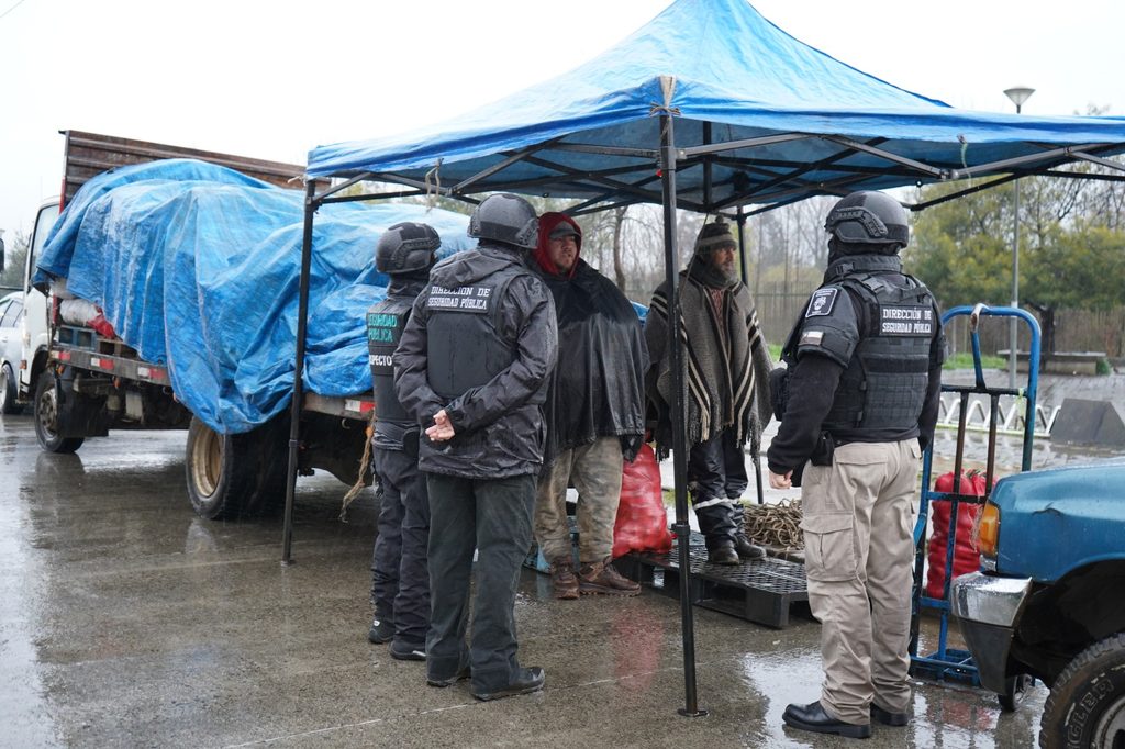 Carabineros y personal municipal fiscalizando la feria libre de Valdivia para asegurar el orden público.