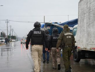 Carabineros y personal municipal fiscalizando la feria libre de Valdivia para asegurar el orden público.
