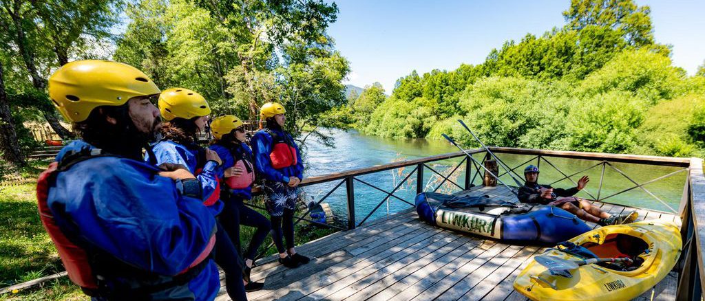 Personas practicando rafting y turismo aventura en un río