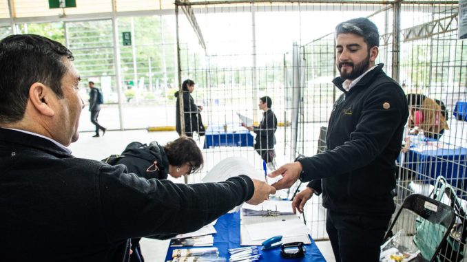 Participantes y empresas reunidos en el Coliseo Municipal de Valdivia durante la feria laboral.