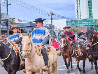 Delegaciones escolares y organizaciones sociales desfilando en el Helipuerto de Valdivia durante las Fiestas Patrias