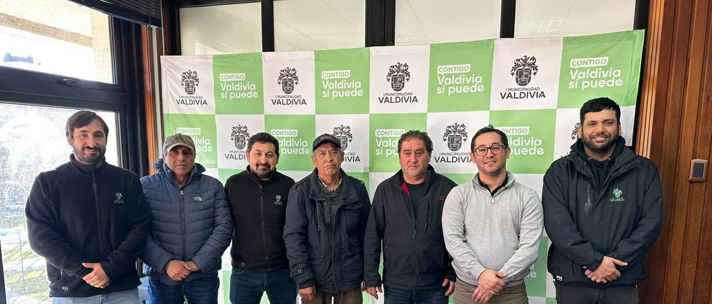 Puestos de feria libre funcionando en una calle de Valdivia con vendedores locales
