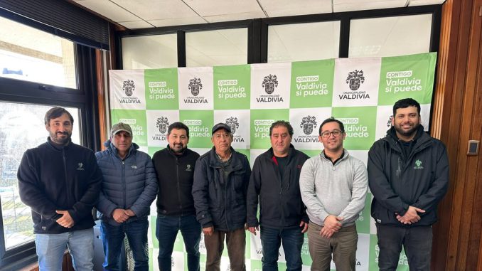 Puestos de feria libre funcionando en una calle de Valdivia con vendedores locales