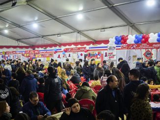 Escenario principal de la Fiesta de las Tradiciones en el Parque Saval de Valdivia con familias disfrutando de actividades culturales