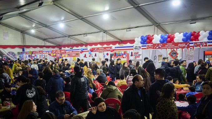 Escenario principal de la Fiesta de las Tradiciones en el Parque Saval de Valdivia con familias disfrutando de actividades culturales