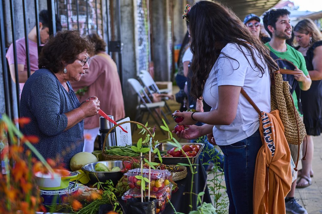 Productores y emprendedores participando en el evento AgroImpacta en el Mercado Estación de Valdivia