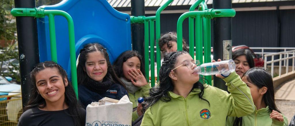 Estudiantes y directora de la Escuela Rural Huillinco posan junto al nuevo sistema de potabilización de agua