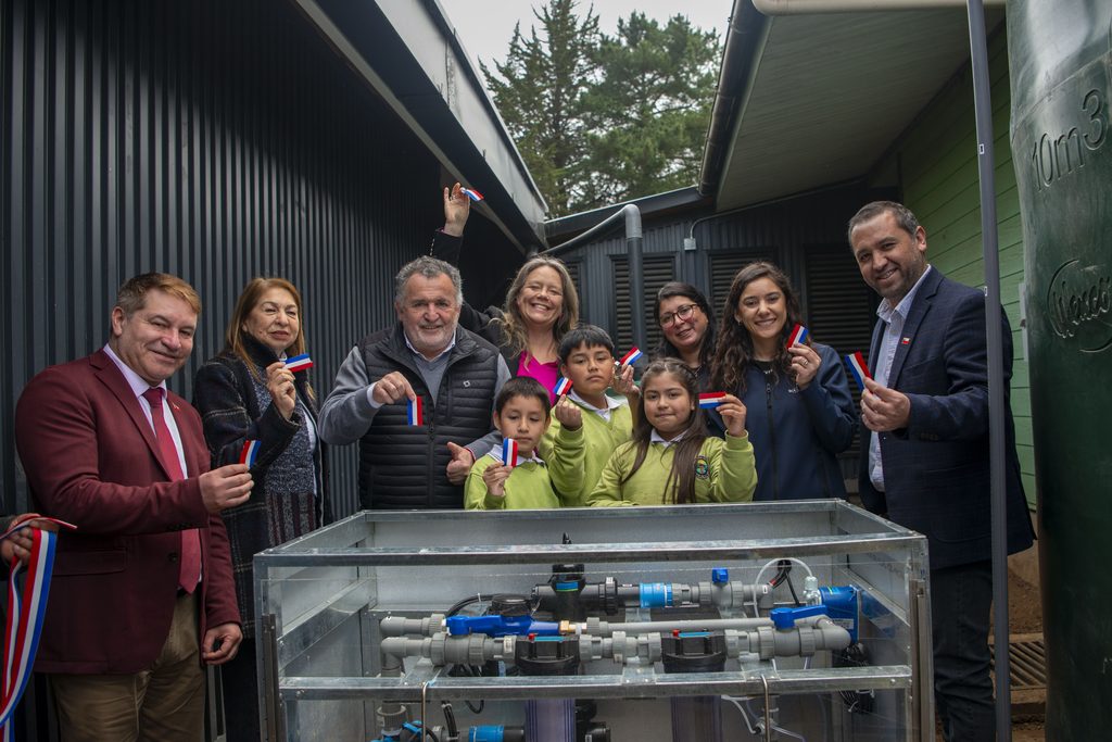Estudiantes y directora de la Escuela Rural Huillinco posan junto al nuevo sistema de potabilización de agua