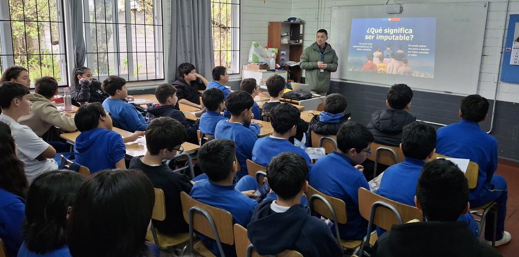 Estudiantes participando en una charla preventiva sobre responsabilidad penal adolescente en un colegio de la región de Los Ríos.